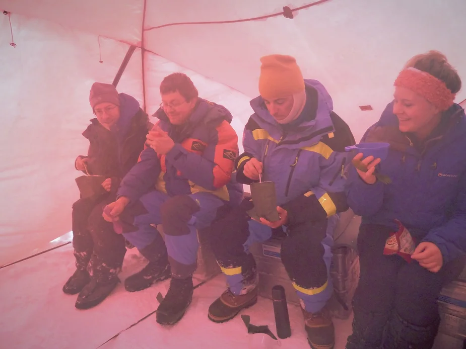 Four people eating in a tent.