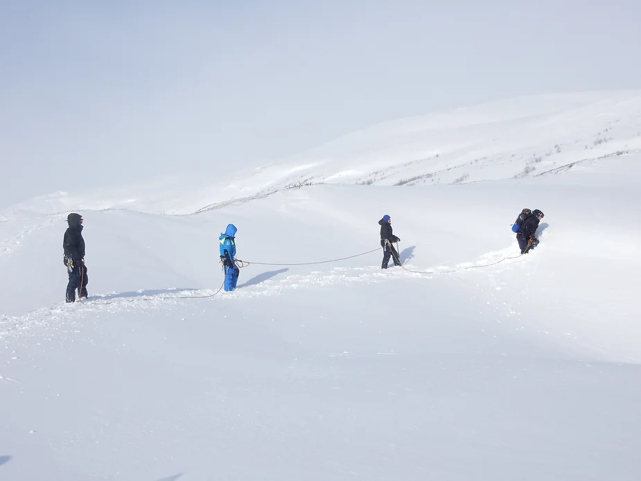 Four people training in the snow.