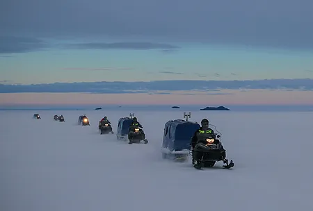 The team traveling via snowmobile.