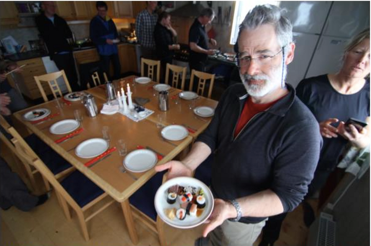 Nat Lifton holding a plate of prepared sushi.