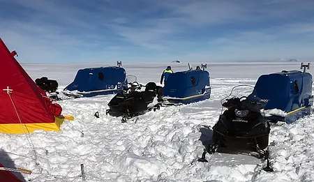 Snowmobiles next to the living modules.